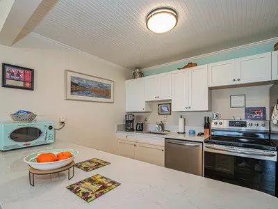 a view of a dining room and livingroom with furniture wooden floor a chandelier