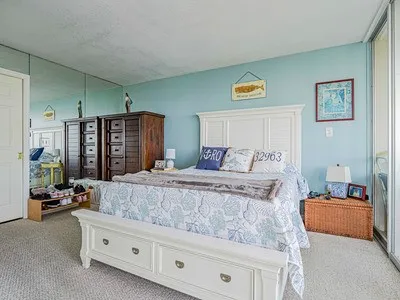 a bedroom with a bed and large windows