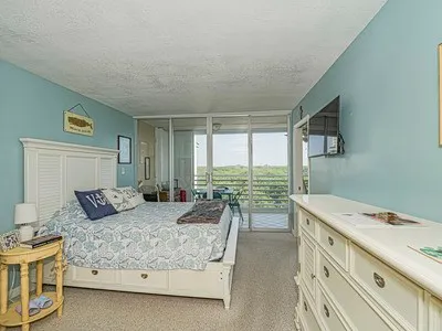 a bedroom with a large bed and a balcony view