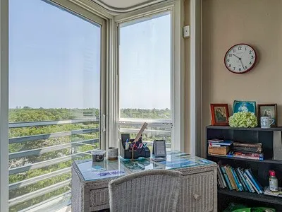 a living room with a rug floor to ceiling windows and pool table