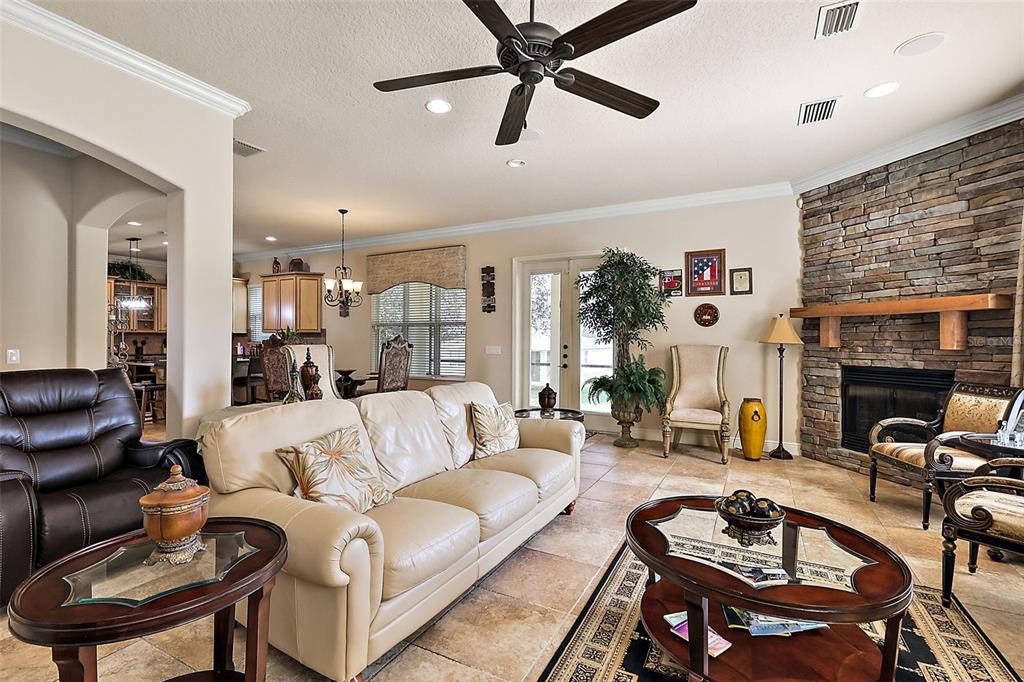 212 Crestrun Loop Leesburg, FL 34748 - Photo 12 of 47 a living room with furniture a fireplace and a flat screen tv
