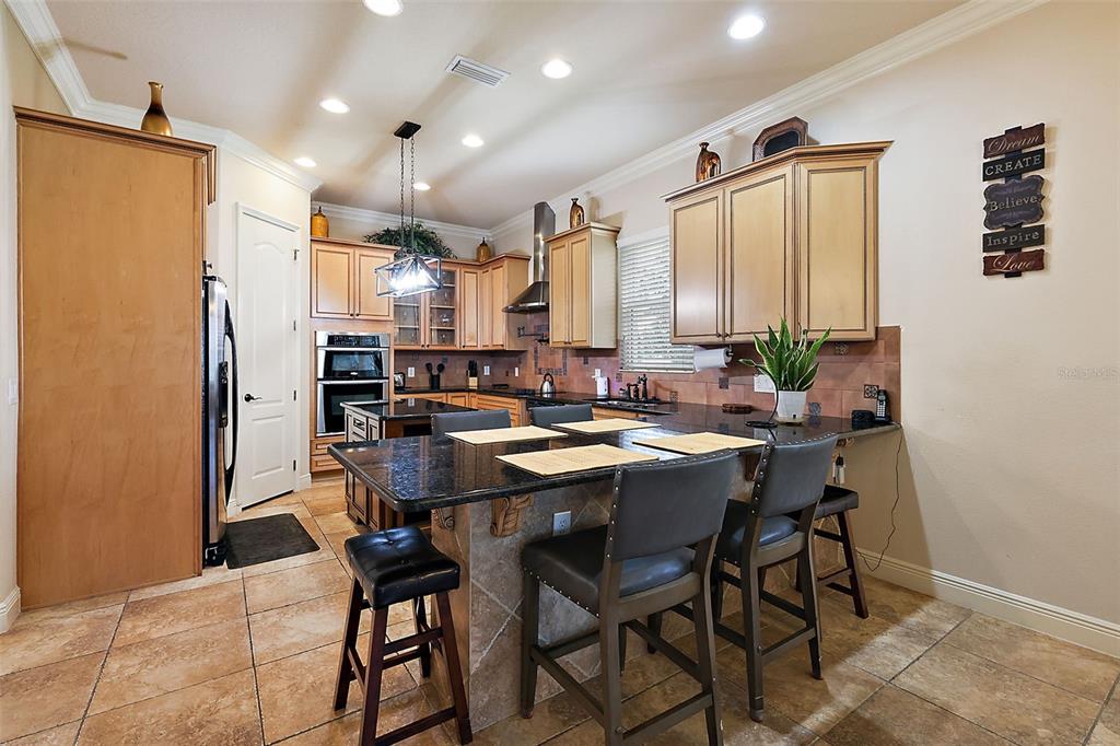 212 Crestrun Loop Leesburg, FL 34748 - Photo 17 of 47 a kitchen with a table chairs refrigerator and cabinets