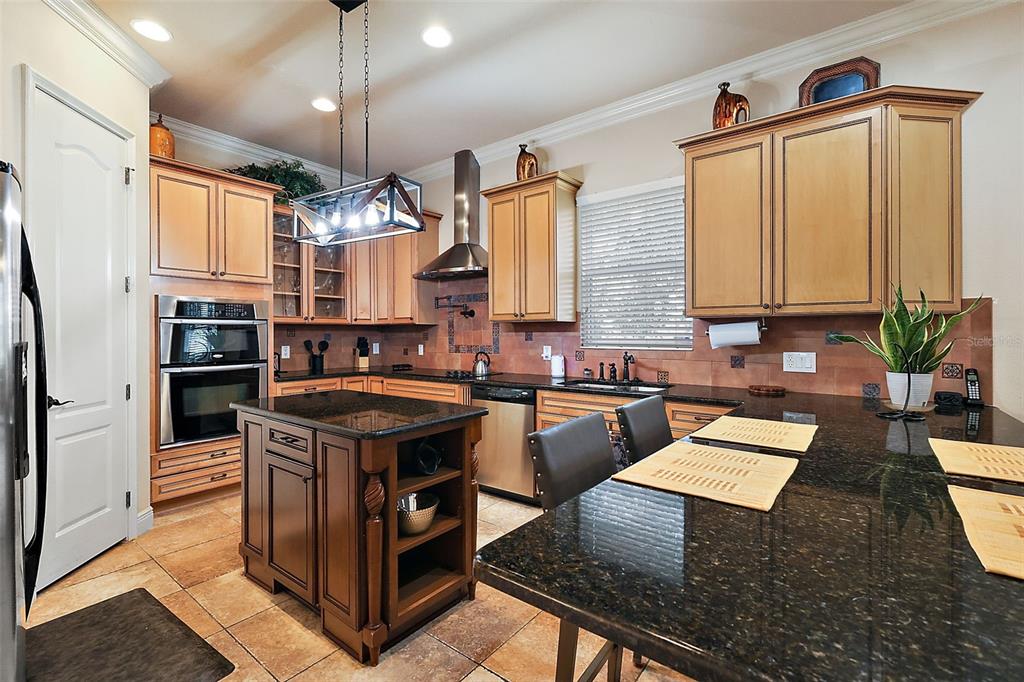212 Crestrun Loop Leesburg, FL 34748 - Photo 18 of 47 a kitchen with stainless steel appliances granite countertop a stove a sink dishwasher and a refrigerator with wooden floor