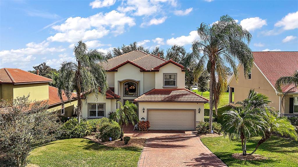 212 Crestrun Loop Leesburg, FL 34748 - Photo 2 of 47 a front view of a house with a yard and garage