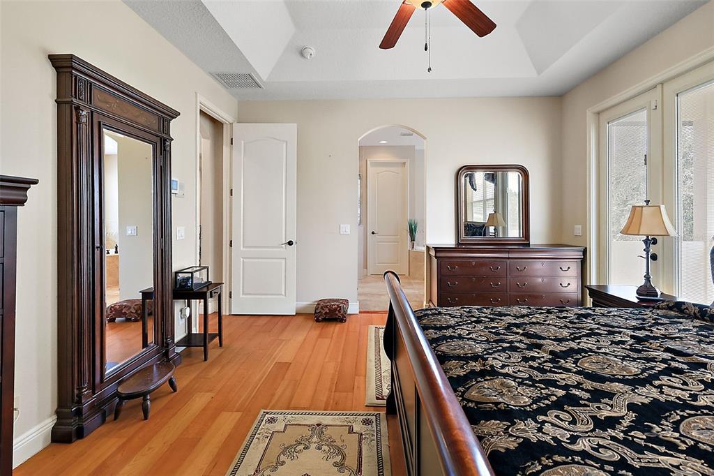 212 Crestrun Loop Leesburg, FL 34748 - Photo 27 of 47 a bedroom with a bed and a dresser with wooden floor