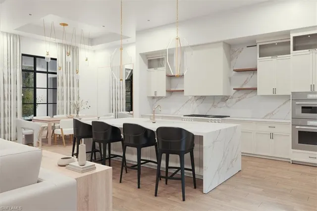 a kitchen with cabinets appliances and a dining table