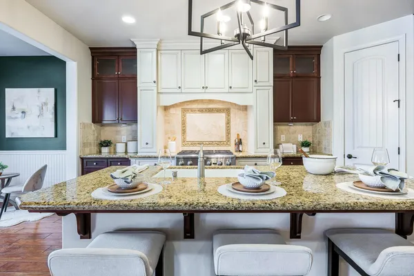 a kitchen with kitchen island granite countertop a sink cabinets and stainless steel appliances