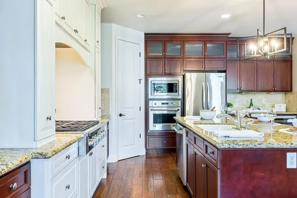 a kitchen with stainless steel appliances granite countertop a kitchen island a stove a table and chairs in it
