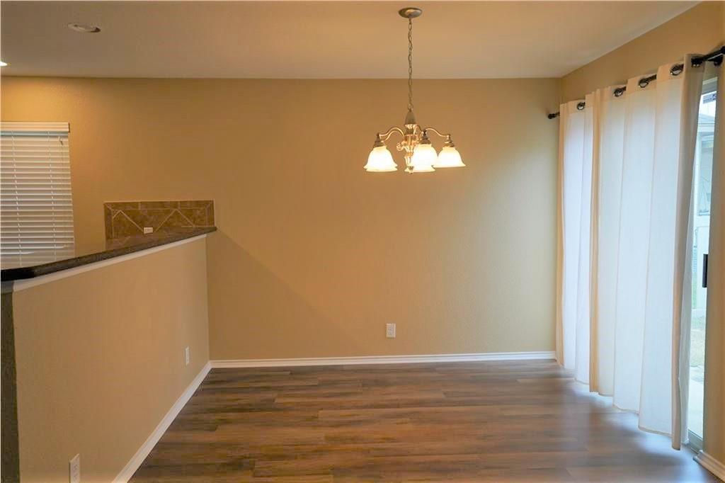201 Edwin Kyle, TX 78640 - Photo 9 of 21 Dining area featuring wood-finish flooring, a contemporary chandelier, and sliding glass door access to the outdoors