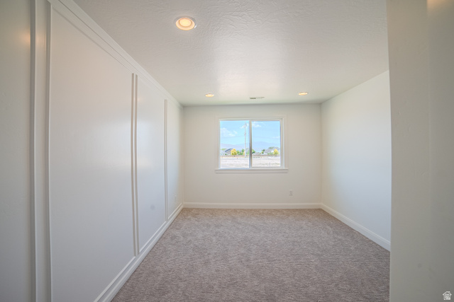 45 North Scarlet Maple Road, Unit 4317 Vineyard, UT 84059 - Photo 28 of 35 Spacious room featuring board and batten accent wall, recessed lighting, and a neutral carpeted floor