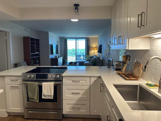a kitchen with granite countertop a stove sink and cabinets