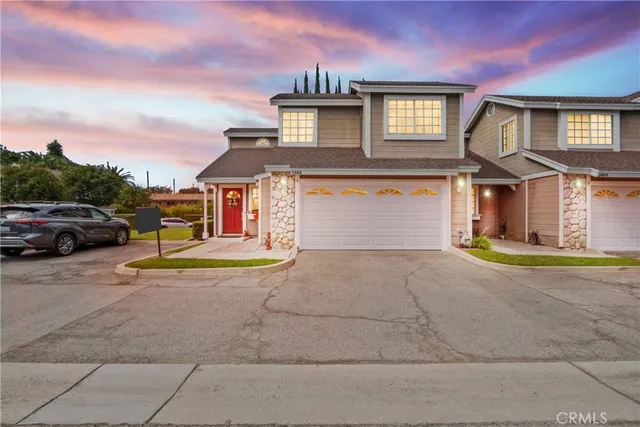a front view of a house with a garden and parking