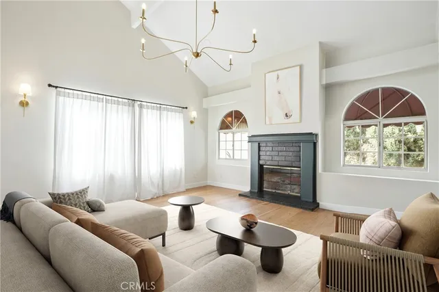 a living room with furniture a fireplace and a large window