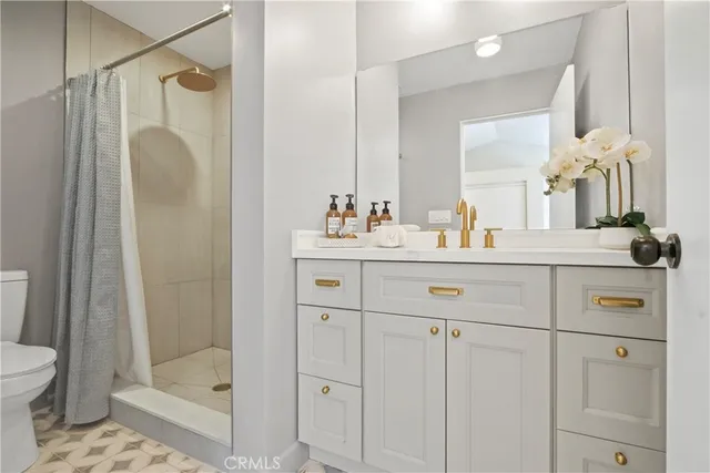 a bathroom with a shower sink vanity and mirror