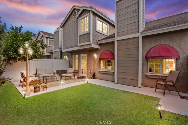 a couple of table and chairs in the back yard of the house