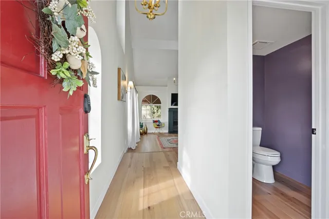 a view of a hallway with wooden floor and a potted plant