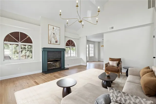 a living room with furniture a fireplace and a large window