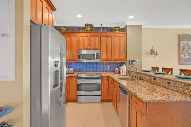 a kitchen with stainless steel appliances granite countertop a stove a sink and a refrigerator