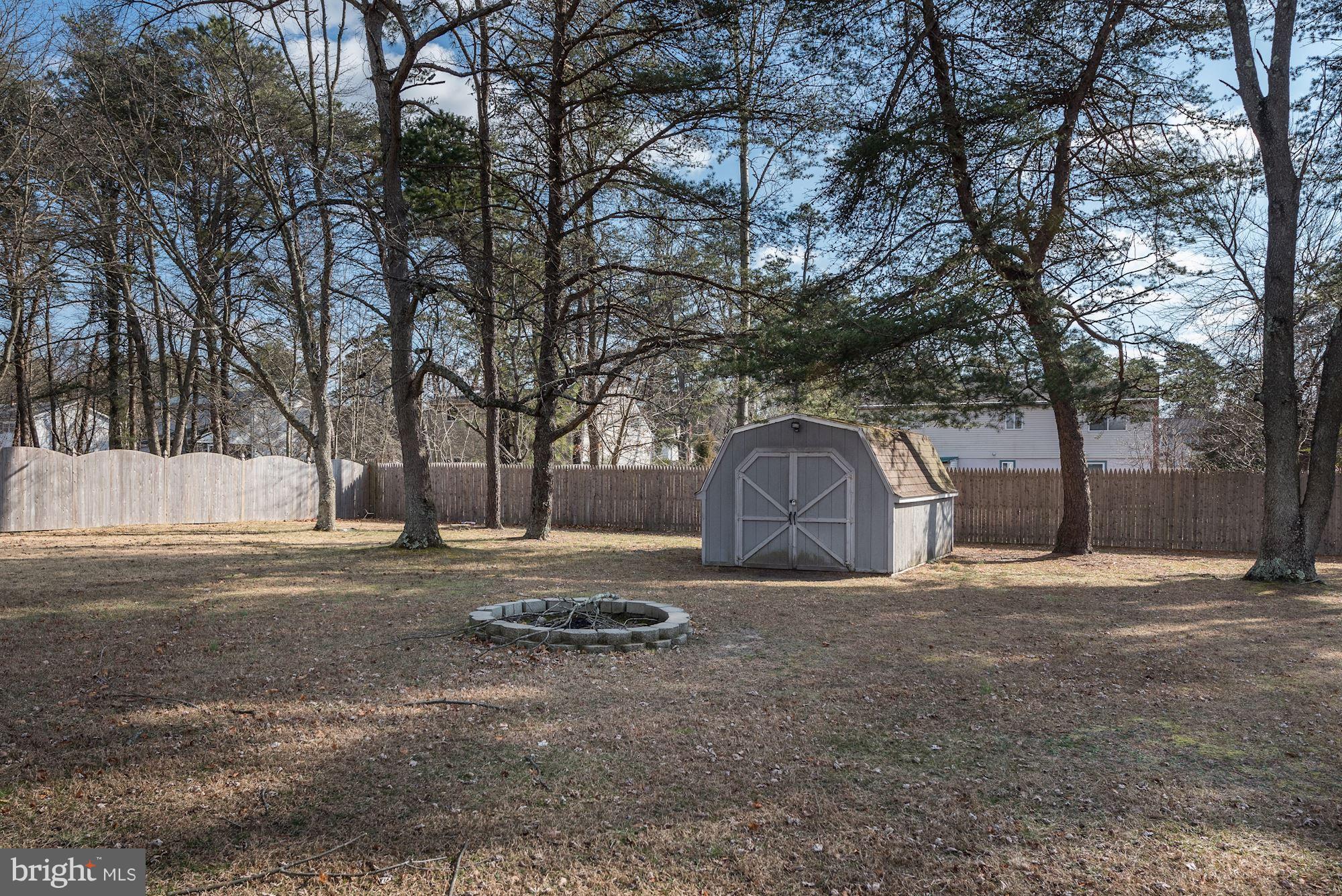 2418 Hopewell Road Marlton, NJ 08053 - Photo 42 of 42 a backyard of a house with large trees and a wooden fence