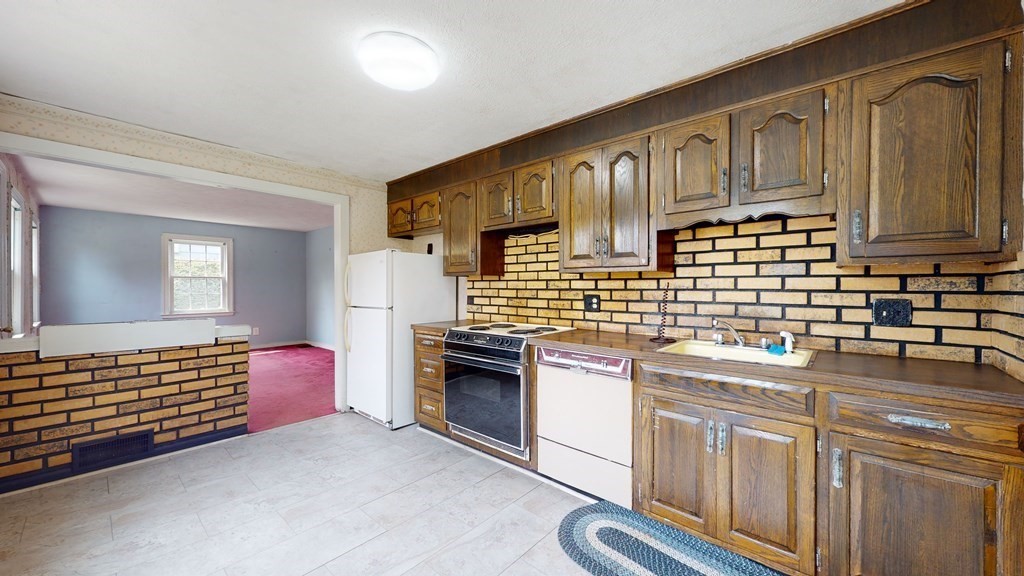 314 Burncoat Street Worcester, MA 01606 - Photo 6 of 29 a kitchen with granite countertop a sink stove and cabinets