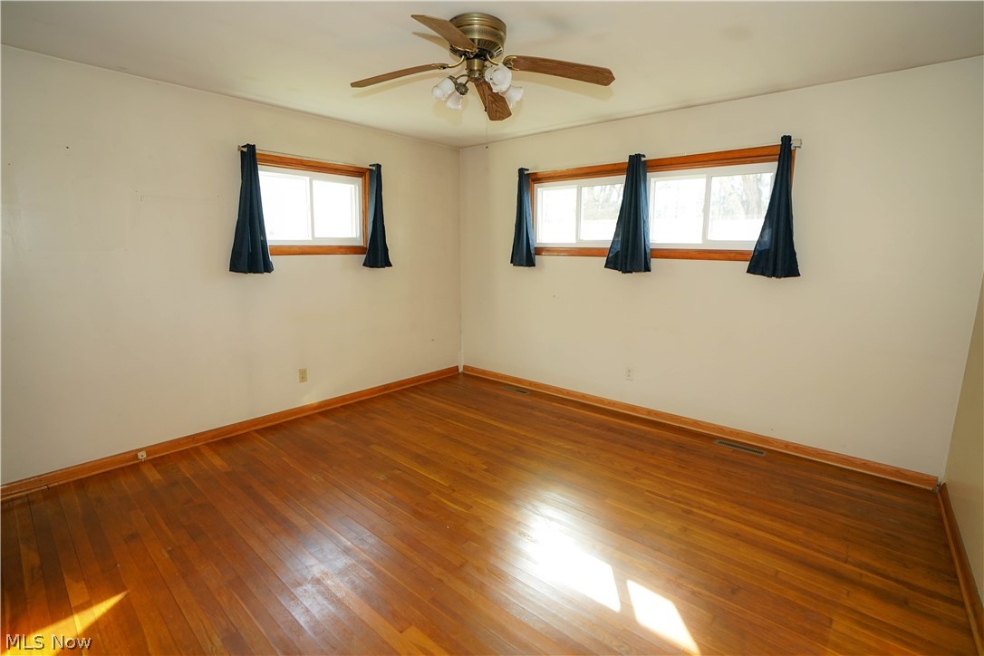 6198 Arrow Road Northwest Minerva, OH 44657 - Photo 6 of 17 Spare room featuring hardwood / wood-style flooring and ceiling fan