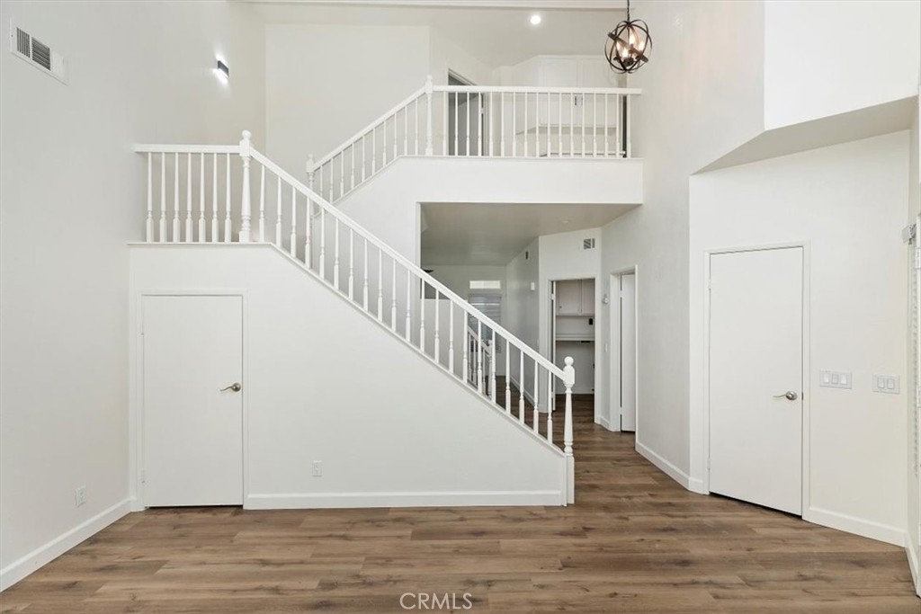 19912 Westerly Drive Riverside, CA 92508 - Photo 5 of 22 a view of staircase with white walls and wooden floor