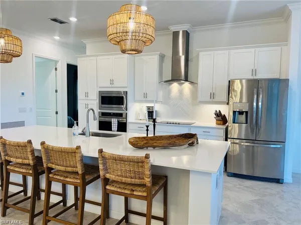 a kitchen with stainless steel appliances a table chairs and a refrigerator