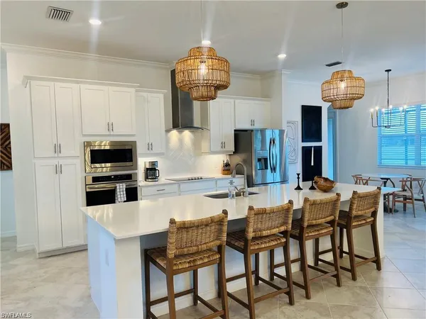 a kitchen with stainless steel appliances a dining table and chairs