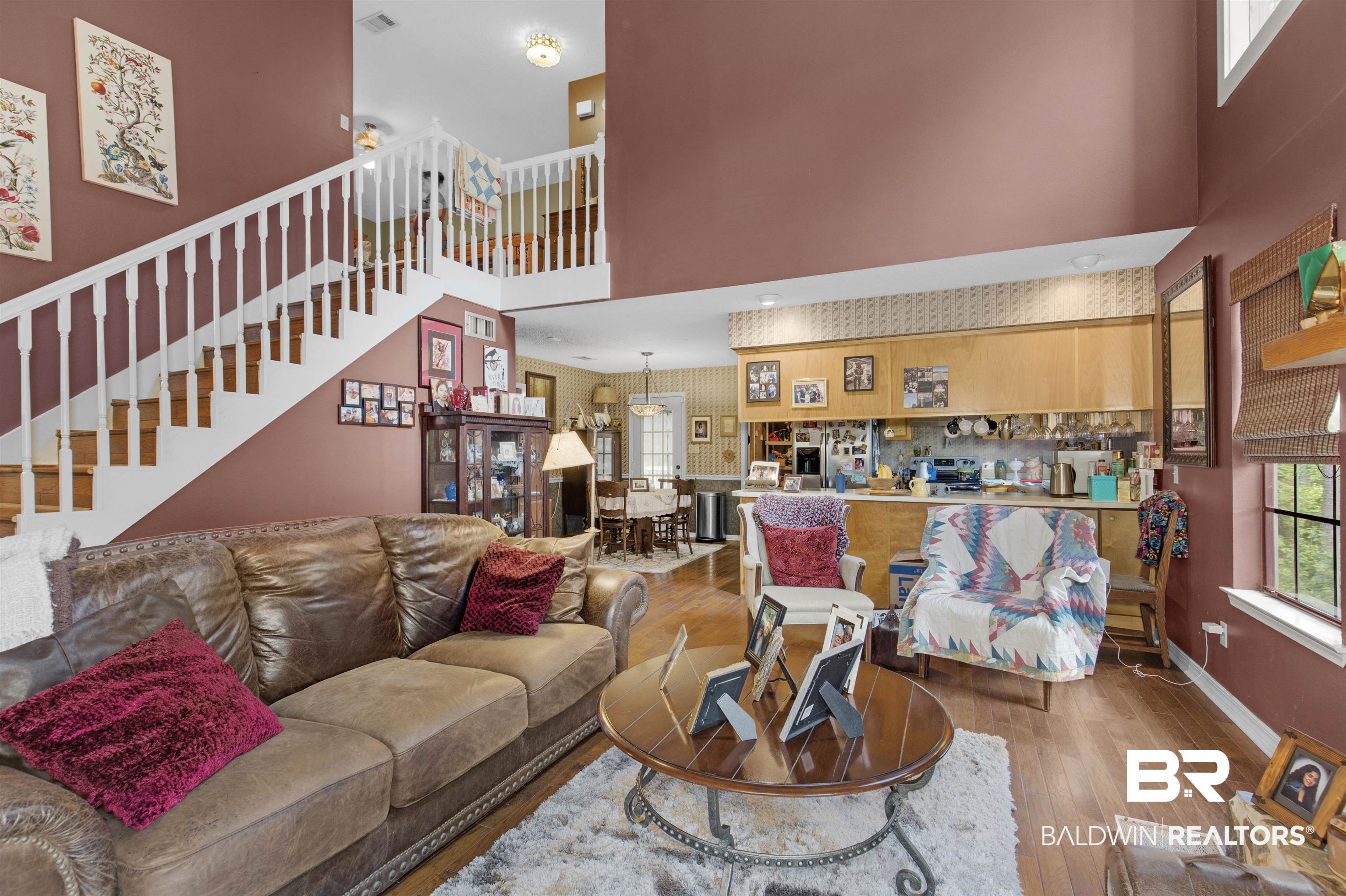 31375 Stagecoach Road Daphne, AL 36527 - Photo 6 of 21 Living area with wood finished floors, a high ceiling, stairs, and baseboards