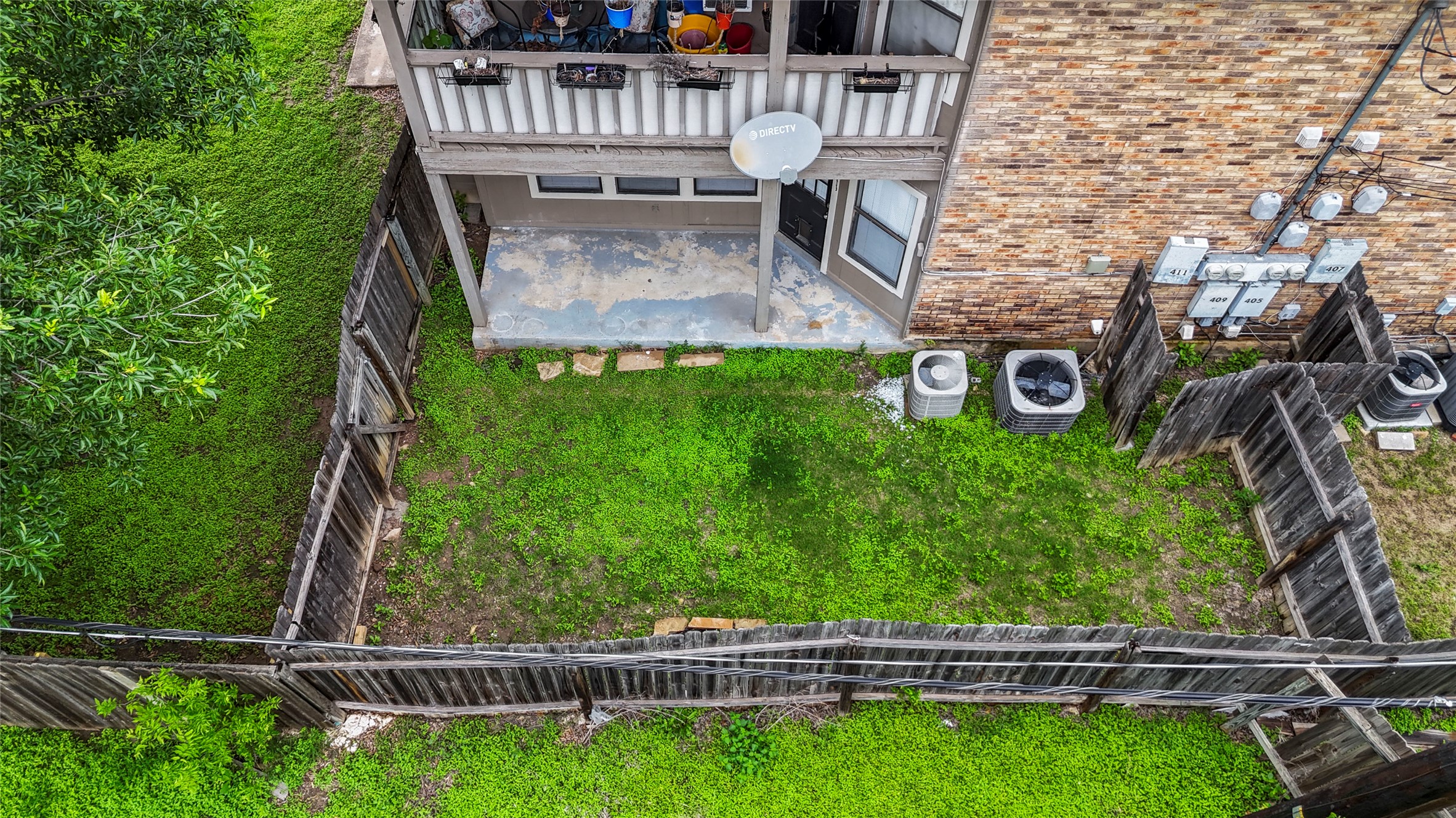 409 Rawhide Loop Round Rock, TX 78681 - Photo 13 of 14 Private fenced backyard featuring a grassy lawn, stone patio, and upper-level balcony