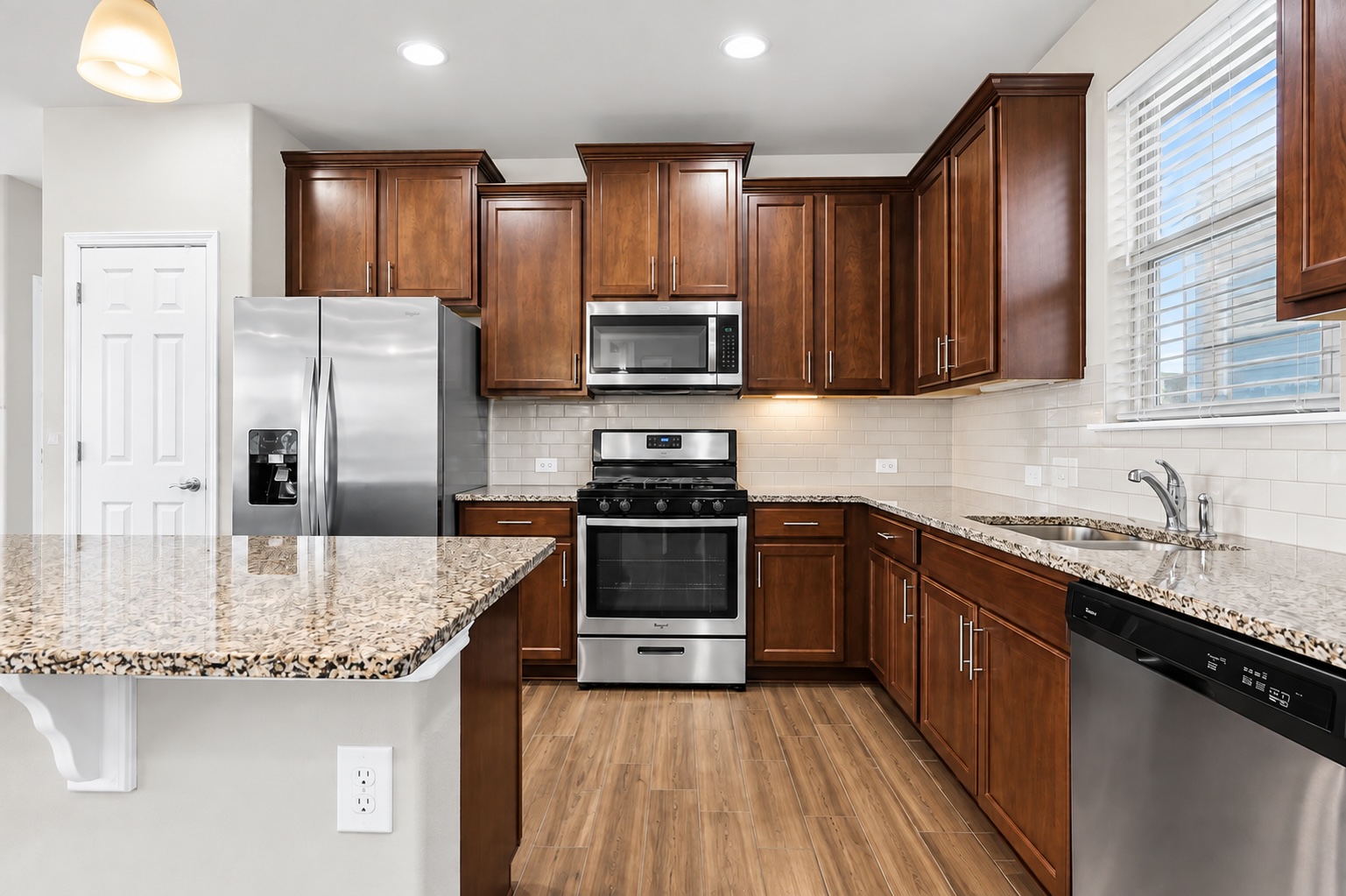 121 Guemal Road Buda, TX 78610 - Photo 5 of 13 Rich wood cabinetry and polished stone countertops elevate this modern cooking space.