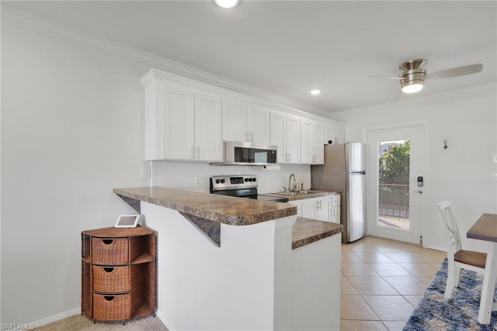 466 12th Avenue South, Unit 466 Naples, FL 34102 - Photo 11 of 34 a kitchen with stainless steel appliances granite countertop a sink stove and refrigerator