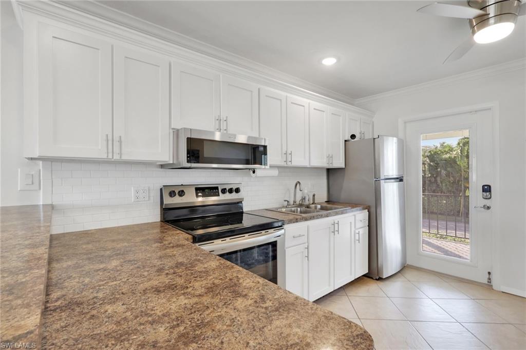 466 12th Avenue South, Unit 466 Naples, FL 34102 - Photo 12 of 34 a kitchen with stainless steel appliances granite countertop a stove a sink and a refrigerator