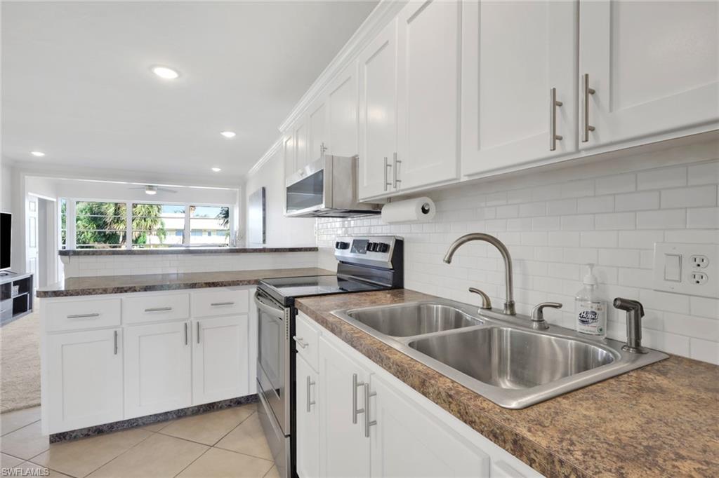 466 12th Avenue South, Unit 466 Naples, FL 34102 - Photo 15 of 34 a kitchen with white cabinets a sink and dishwasher