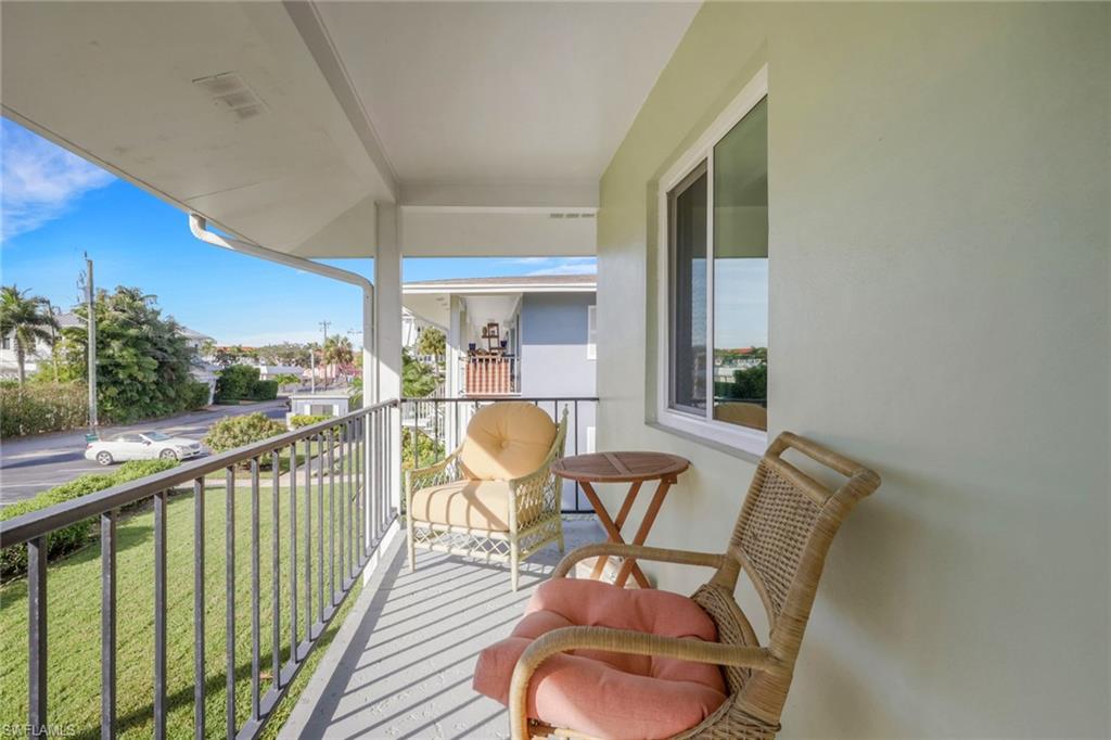 466 12th Avenue South, Unit 466 Naples, FL 34102 - Photo 4 of 34 a balcony with table and chairs