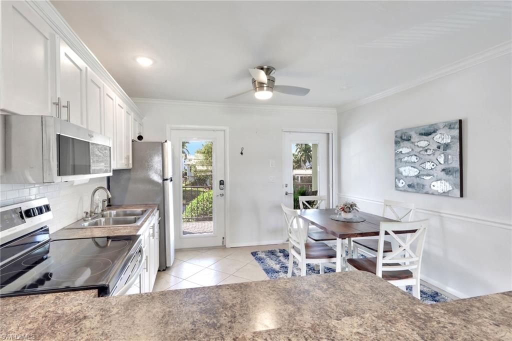 466 12th Avenue South, Unit 466 Naples, FL 34102 - Photo 6 of 34 a living room with stainless steel appliances granite countertop furniture a fireplace a flat screen tv and a couch