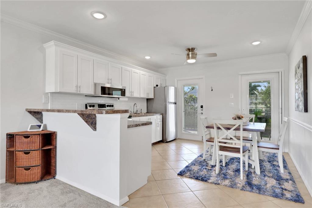 466 12th Avenue South, Unit 466 Naples, FL 34102 - Photo 7 of 34 a living room with furniture a dining table and kitchen view