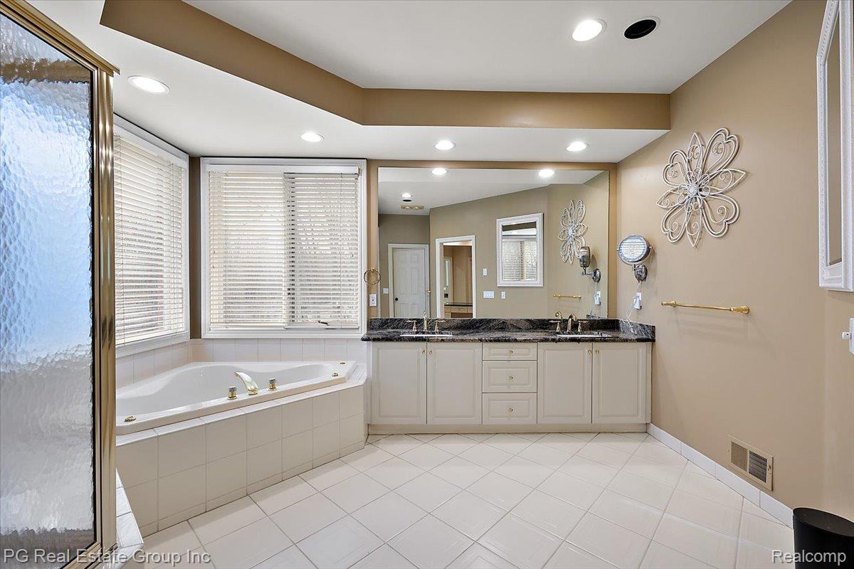3571 Cedar Brook Drive Rochester, MI 48309 - Photo 37 of 57 Bathroom featuring double vanity, a garden tub, light tile patterned floors, recessed lighting, and a shower stall