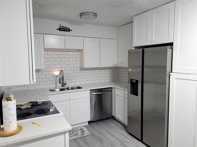 a kitchen with a refrigerator sink and cabinets
