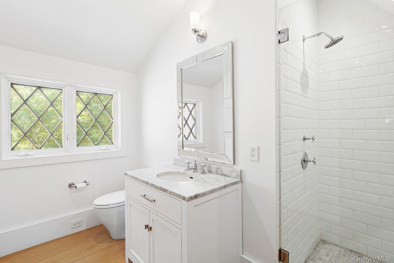 123 Abrahams Path East Hampton, NY 11937 - Photo 20 of 27 a bathroom with a double vanity sink a toilet and a window