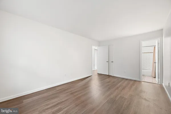 a view of an empty room with wooden floor