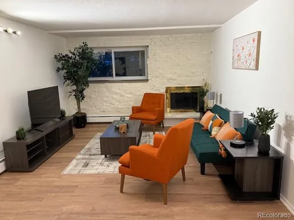 a living room with furniture a potted plant and a fireplace