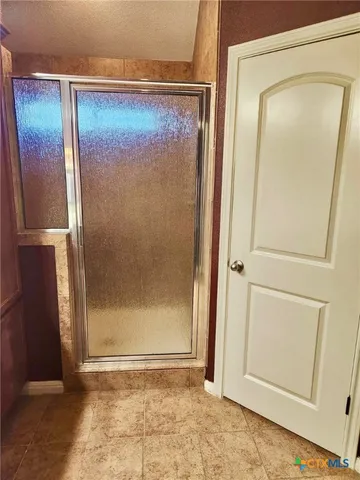 an empty room with wooden floor and a glass door