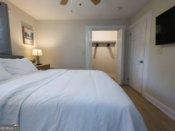 a bedroom with a bed and a flat tv screen on dresser