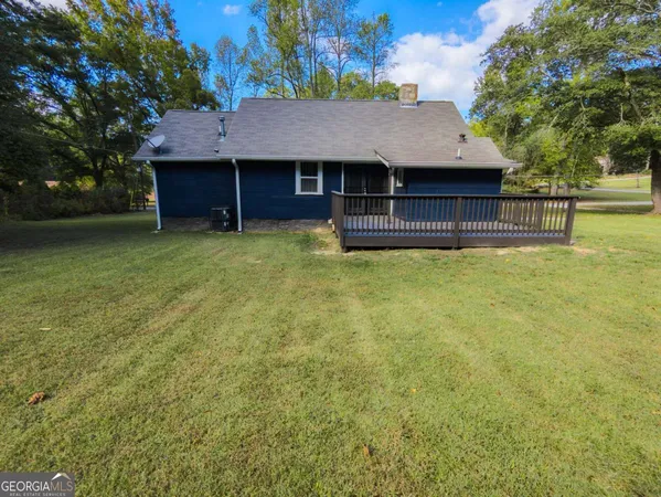 a view of a house with a backyard and a tree