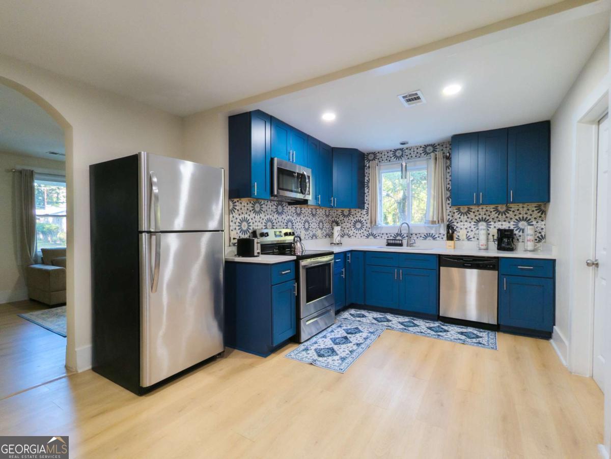 6557 Woodrow Road Lithonia, GA 30038 - Photo 7 of 17 a kitchen with a refrigerator sink and cabinets