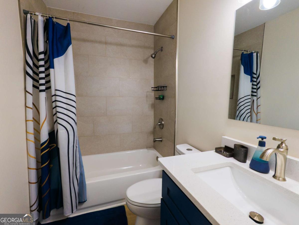 6557 Woodrow Road Lithonia, GA 30038 - Photo 8 of 17 a bathroom with a sink a toilet and a shower
