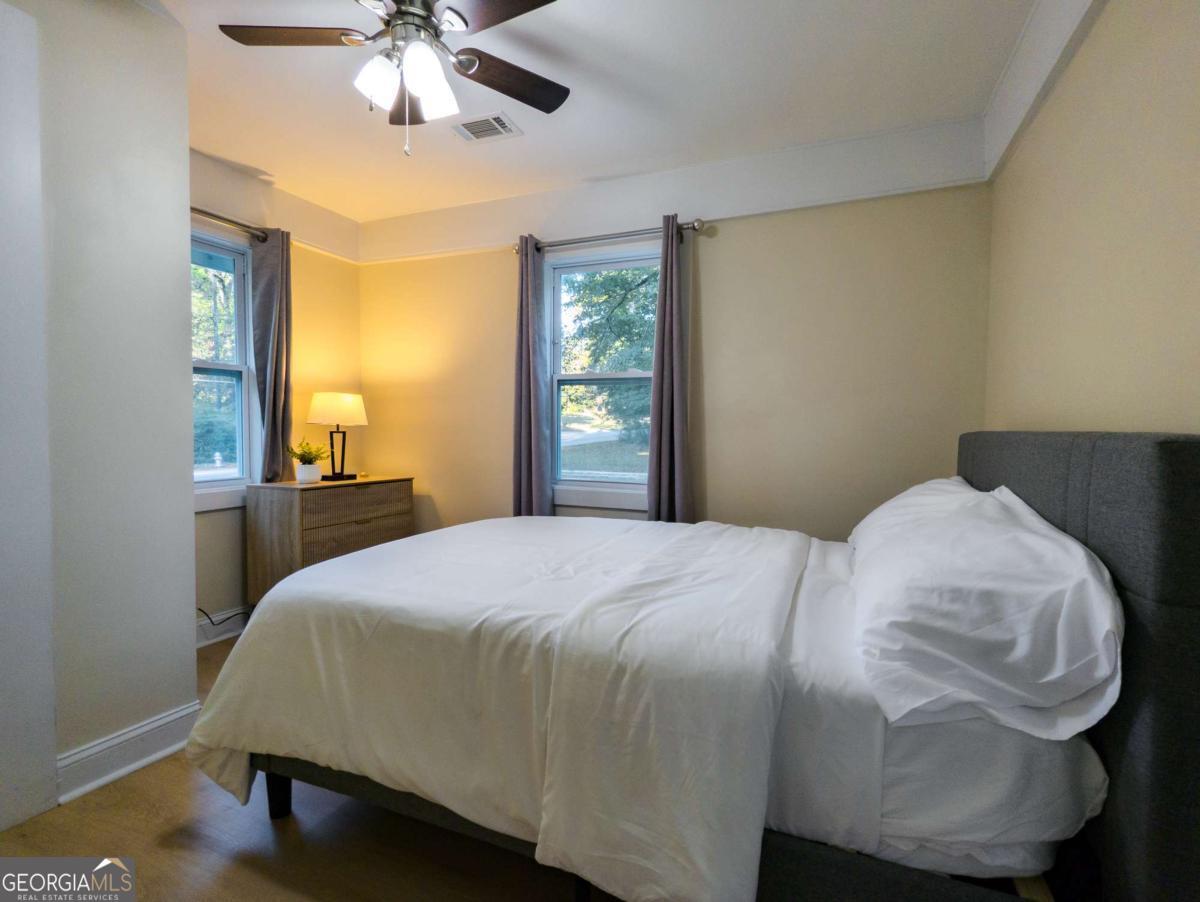 6557 Woodrow Road Lithonia, GA 30038 - Photo 9 of 17 a bedroom with a bed and wooden floor