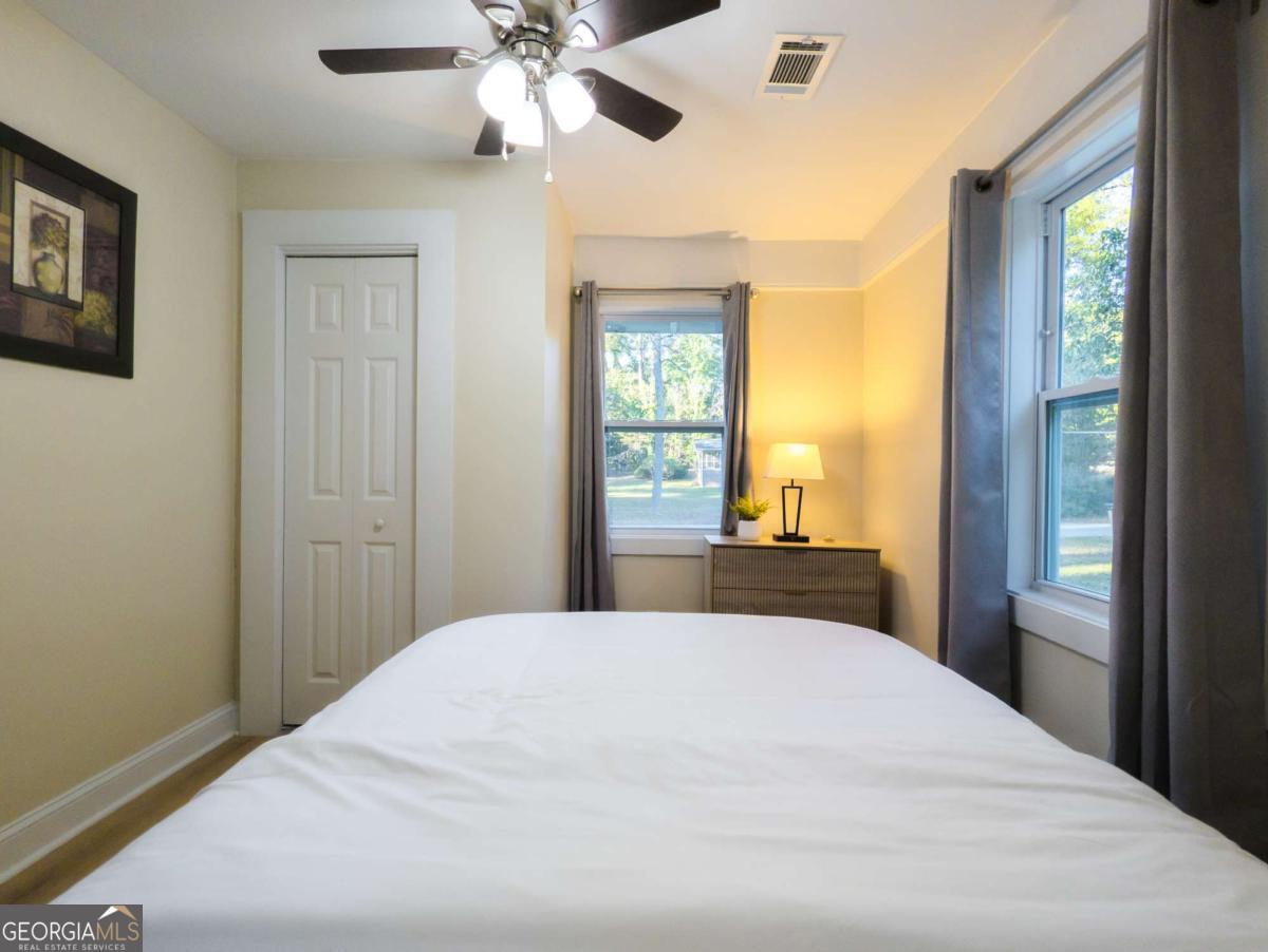 6557 Woodrow Road Lithonia, GA 30038 - Photo 10 of 17 a bedroom with a large bed and a chandelier