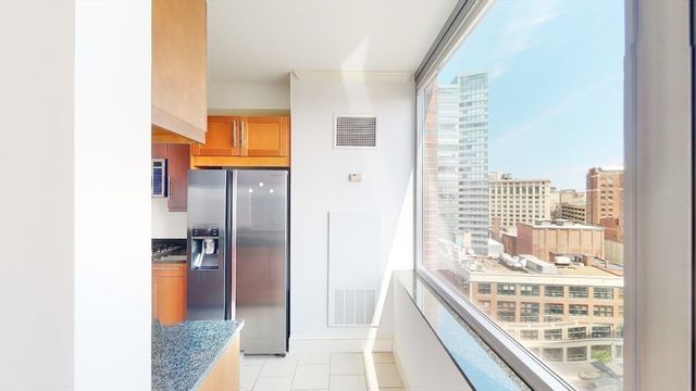 a kitchen with granite countertop a refrigerator and a sink